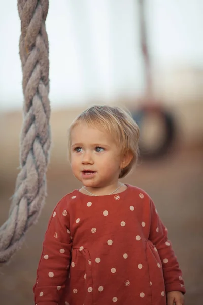 Portrait d'une jolie petite fille en robe rouge. Un enfant marche sous le soleil de l'automne — Photo