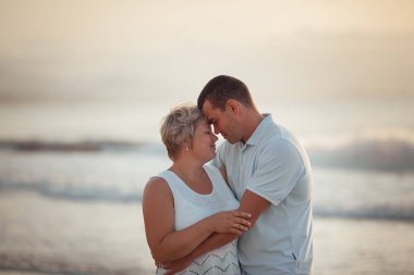 Portrait of a happy lovers husband and wife. Couple walks along the sea at sunrise