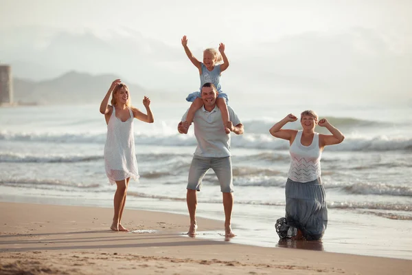 Портрет счастливой семьи. Они обнимаются на фоне моря . — стоковое фото