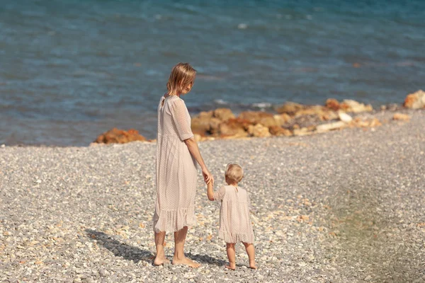 Bastante feliz mamá y su hija pequeña en un paseo cerca del mar —  Fotos de Stock