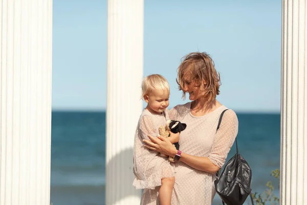 Bastante feliz mamá y su hija pequeña en un paseo cerca del mar — Foto de Stock