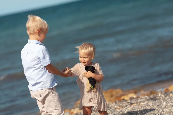 Fille et garçon jouent au bord de la mer . — Photo