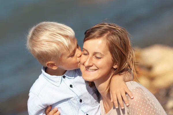 Portrait of happy beautiful mom and son on sea background — 图库照片