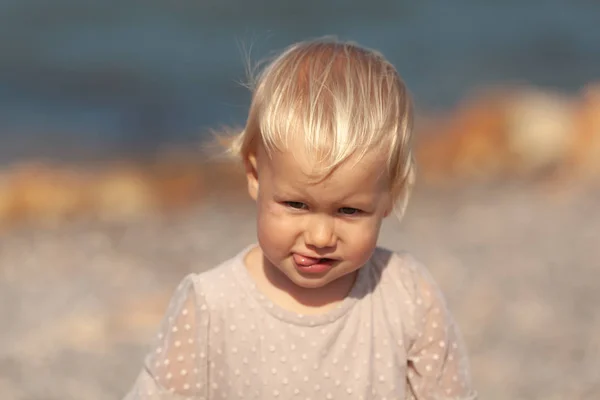 Portret ślicznej dziewczynki na tle morza, dziecko spaceruje po brzegu — Zdjęcie stockowe