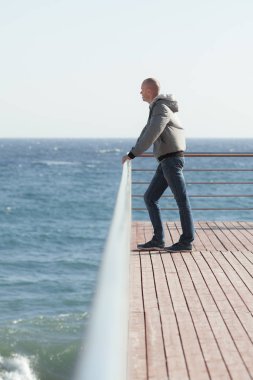 Deniz kıyısında duran genç bir adam