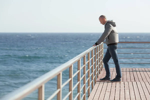 Um jovem de pé na costa do mar — Fotografia de Stock