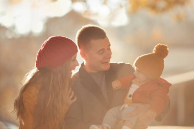 Beautiful happy family on a walk in the autumn park