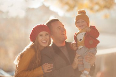 Beautiful happy family on a walk in the autumn park