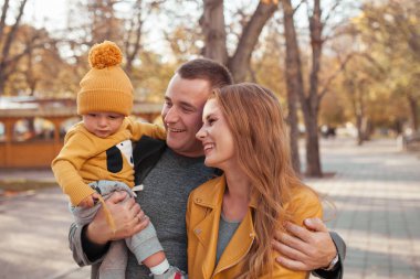 Beautiful happy family on a walk in the autumn park