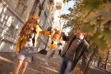 Beautiful happy family on a walk in the autumn park