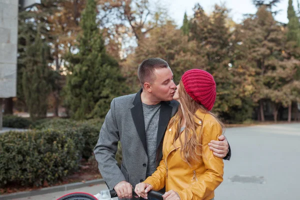 Feliz casal bonito jovem em um passeio no parque de outono. Abraçam e beijam — Fotografia de Stock
