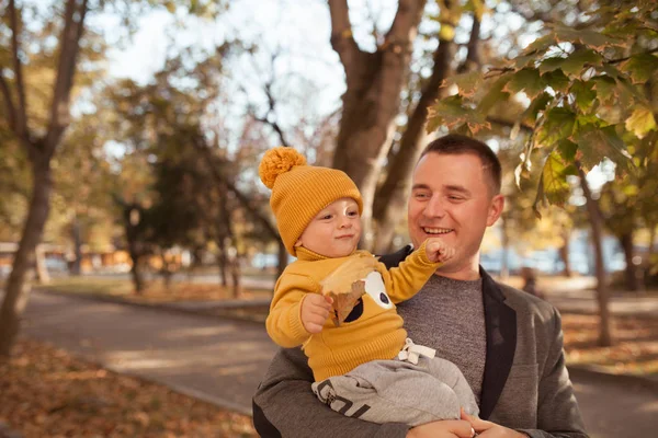 Красивый счастливый отец и сын на прогулке в осеннем парке , — стоковое фото