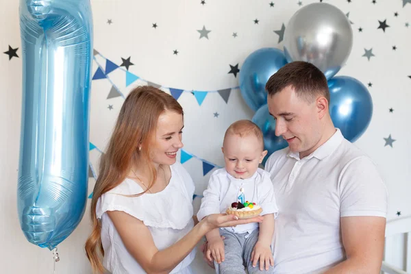 Retrato de mãe feliz, pai e bebê no fundo de decorações de aniversário — Fotografia de Stock