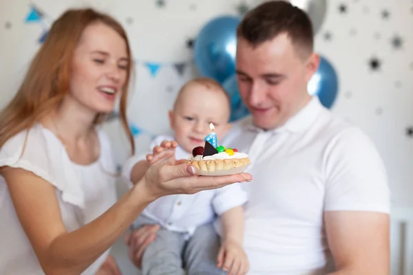 Doğum günü dekorasyonunun arka planında mutlu anne, baba ve bebeğin portresi — Stok fotoğraf