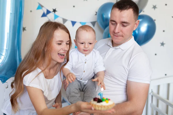 Doğum günü dekorasyonunun arka planında mutlu anne, baba ve bebeğin portresi — Stok fotoğraf