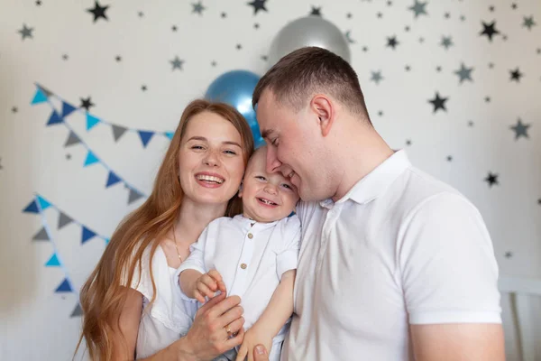 誕生日の装飾の背景に幸せな母親、父と赤ちゃんの肖像画 — ストック写真