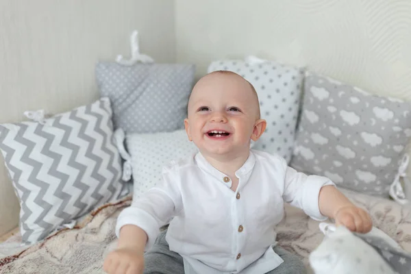 Retrato de uma criança feliz. A criança se senta no sofá e ri — Fotografia de Stock