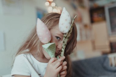 İçerde kumaş laleleri olan neşeli bir kızın portresi.