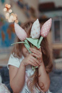 İçerde kumaş laleleri olan neşeli bir kızın portresi.