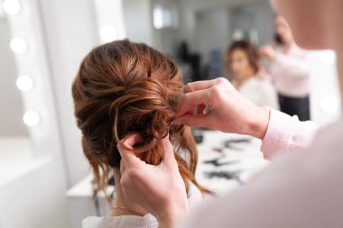 Parlak bir kuaförde kuaför işi, kız kıvırcık ve bir sürü güzel model yapıyor, kapalı bir yerde.