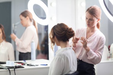 Parlak bir kuaförde kuaför işi, kız kıvırcık ve bir sürü güzel model yapıyor, kapalı bir yerde.
