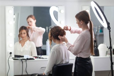 Parlak bir kuaförde kuaför işi, kız kıvırcık ve bir sürü güzel model yapıyor, kapalı bir yerde.