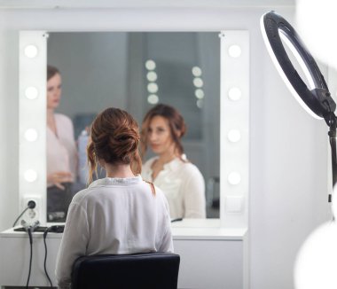 Parlak bir kuaförde kuaför işi, kız kıvırcık ve bir sürü güzel model yapıyor, kapalı bir yerde.