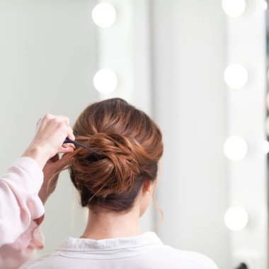 Parlak bir kuaförde kuaför işi, kız kıvırcık ve bir sürü güzel model yapıyor, kapalı bir yerde.