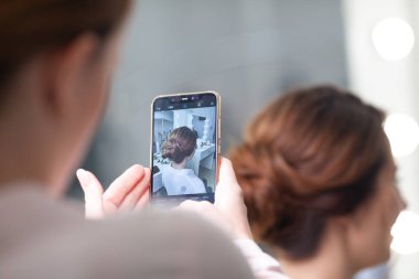 Parlak bir kuaförde kuaför işi, kız kıvırcık ve bir sürü güzel model yapıyor, kapalı bir yerde.