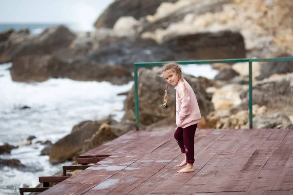 Mutlu Küçük Kız Denizin Kayaların Arkasında Çıplak Ayakla Tahta Bir — Stok fotoğraf