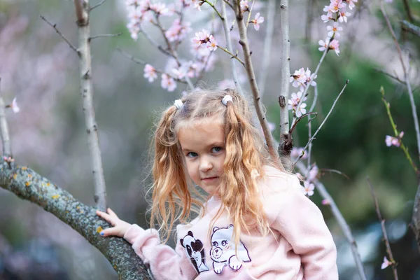 Portret Pięknej Szczęśliwej Dziewczynki Tle Kwitnących Różowych Migdałów Świeżym Powietrzu — Zdjęcie stockowe