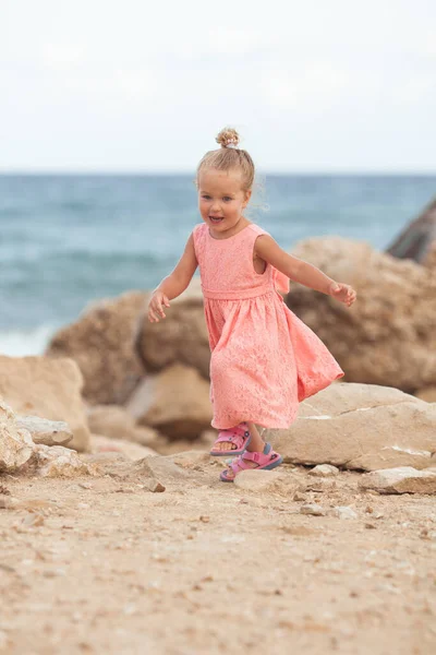 Deniz Kıyısında Küçük Bir Kız Yürüyor Mercan Bir Elbise Giyiyor — Stok fotoğraf