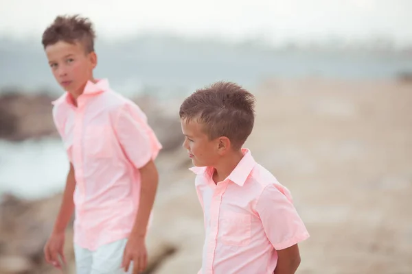 Ritratto Due Fratelli Felici Camicie Corallo Uno Sfondo Pietre Mare — Foto Stock