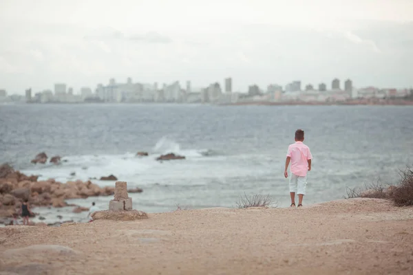 一个孩子在海滨散步 他穿着一件珊瑚色的衬衫 男孩在海上旅行 — 图库照片