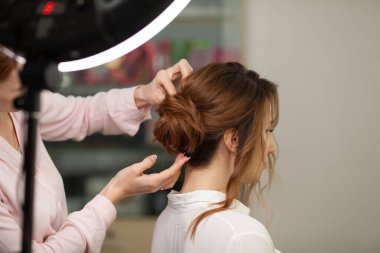 Parlak bir kuaförde kuaför işi, kız kıvırcık ve bir sürü güzel model yapıyor, kapalı bir yerde.