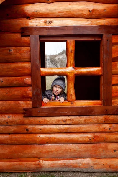 Κοριτσάκι Κοιτάζει Έξω Από Παράθυρο Ενός Ξύλινου Σπιτιού Στην Παιδική — Φωτογραφία Αρχείου