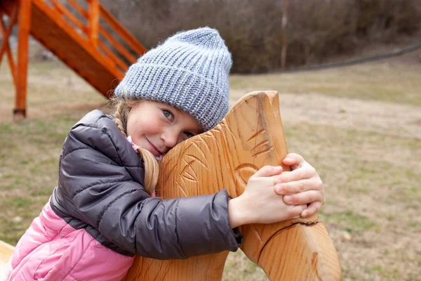 Kleines Mädchen Sitzt Auf Einem Holzpferd Eines Hauses Auf Einem — Stockfoto
