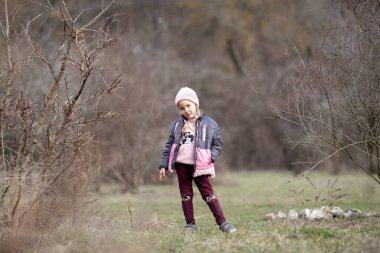 Tatlı kız ormanda, doğada, dışarıda yürüyor.