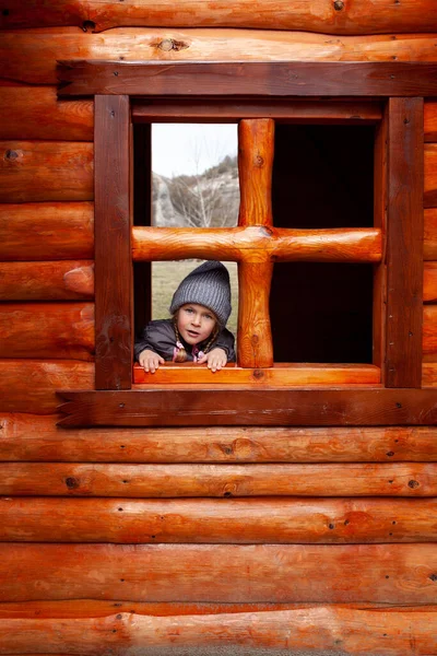 Kleines Mädchen Schaut Aus Dem Fenster Eines Holzhauses Auf Dem — Stockfoto