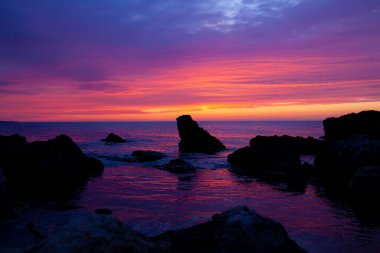 Güzel kırmızı-turuncu gün batımı Denizde, renkli gökyüzü ve deniz, büyülü manzara