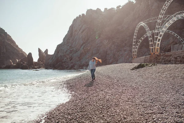 Mutlu Güzel Kız Deniz Kıyısı Boyunca Yürür Deniz Kayaların Arkasında — Stok fotoğraf