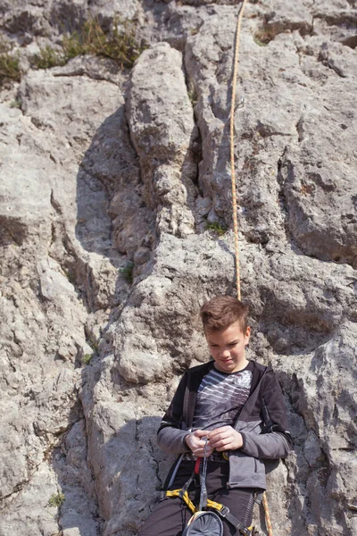 一个在岩石上的青少年从事攀岩 大自然中的儿童运动和儿童户外活动 — 图库照片