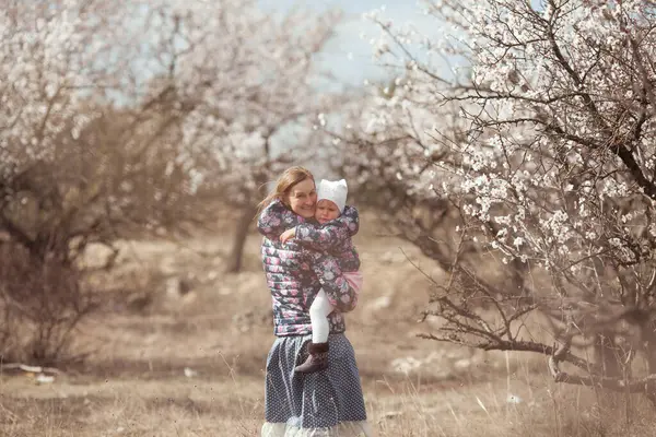 Portret Van Een Gelukkige Moeder Dochter Een Achtergrond Van Amandelbomen — Stockfoto