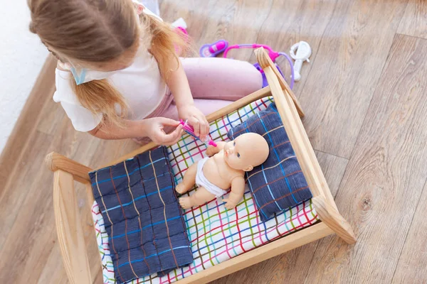 Menina Trata Uma Boneca Uma Criança Brinca Com Médico Sala — Fotografia de Stock