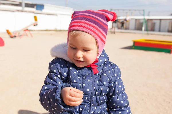 子供は手にテントウムシを抱いている少女を見て 手のひらに虫がいるのを見る — ストック写真