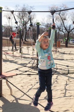 Çocuk tırmanmak için duvara tırmanıyor. Çocuklar çocuk parkında kaya tırmanışçısı
