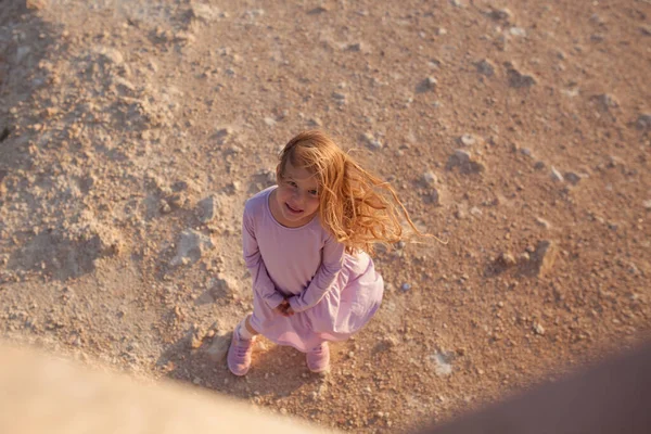 一个快乐快乐的女孩的画像 长发飘逸 一个小孩在橙色的地球上行走 照片来自上方 — 图库照片