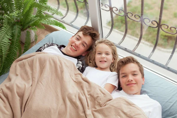 Kleine Mädchen Und Ältere Brüder Liegen Auf Einem Sofa Fenster — Stockfoto