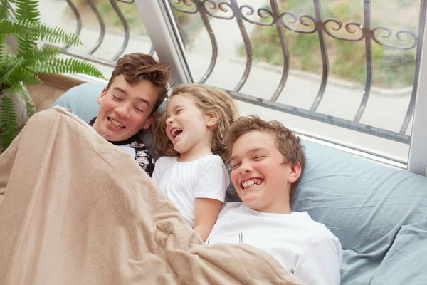 Κοριτσάκι Και Μεγαλύτερα Αδέλφια Είναι Ξαπλωμένοι Έναν Καναπέ Κοντά Στο — Φωτογραφία Αρχείου