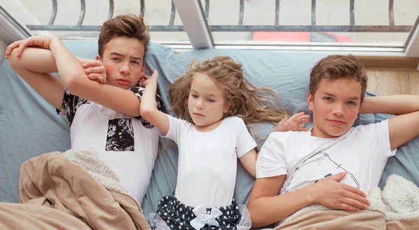Kleine Mädchen Und Ältere Brüder Liegen Auf Einem Sofa Fenster — Stockfoto